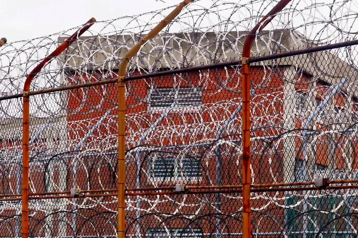 Thick spools of barbed wire surround a jail complex on Rikers Island.